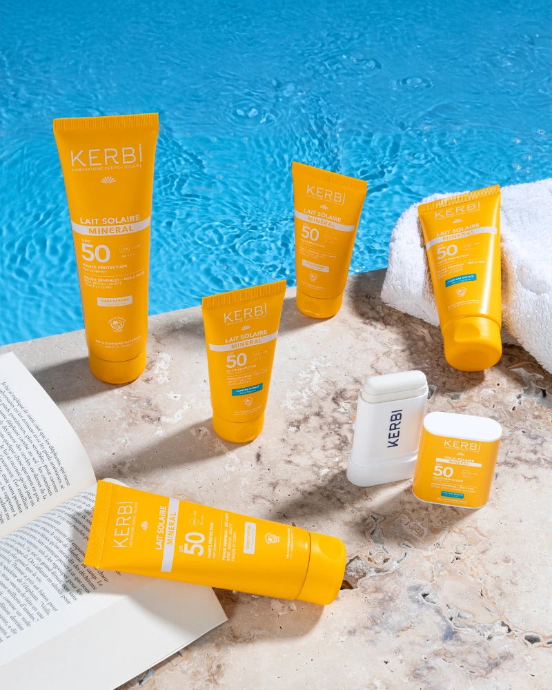 Gamme de laits solaires minéraux SPF 50 Kerbi au bord d’une piscine, protections solaires haute protection visage et corps, filtres minéraux pour peaux sensibles, résistantes à l’eau.