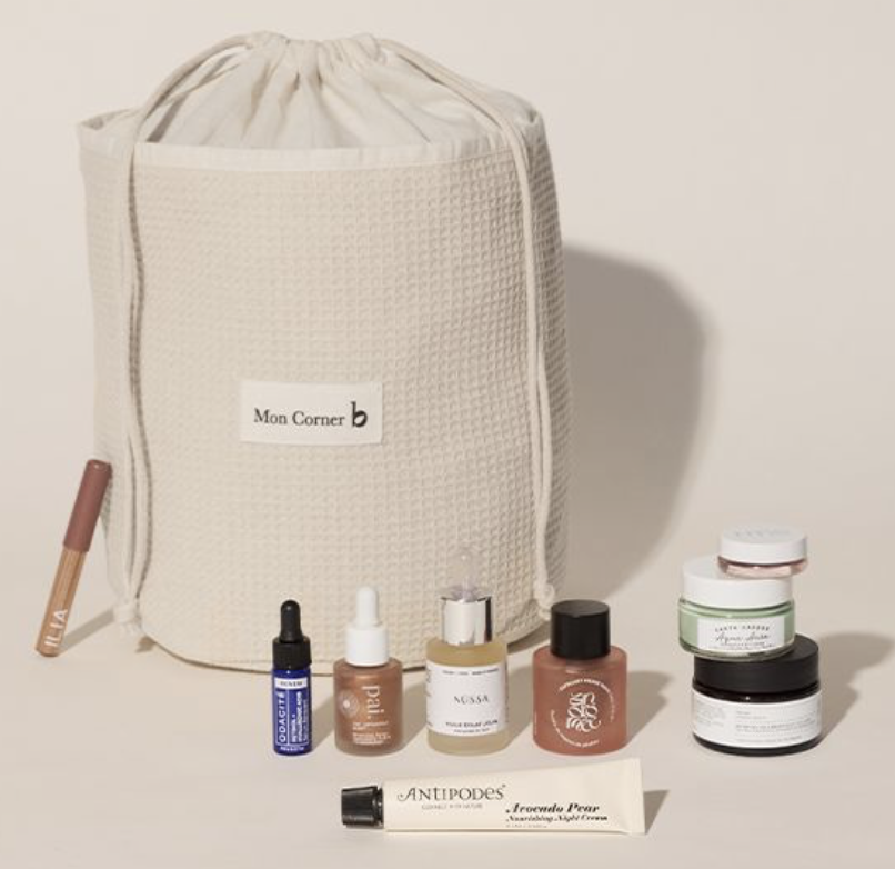 Pochon en tissu blanc écru de la marque "mon corner b" avec diverses cosmétiques devant de diverses marques 